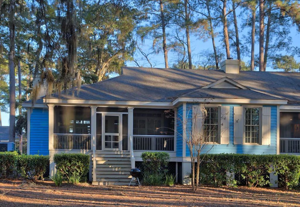 A blue and white house with a screened in porch
