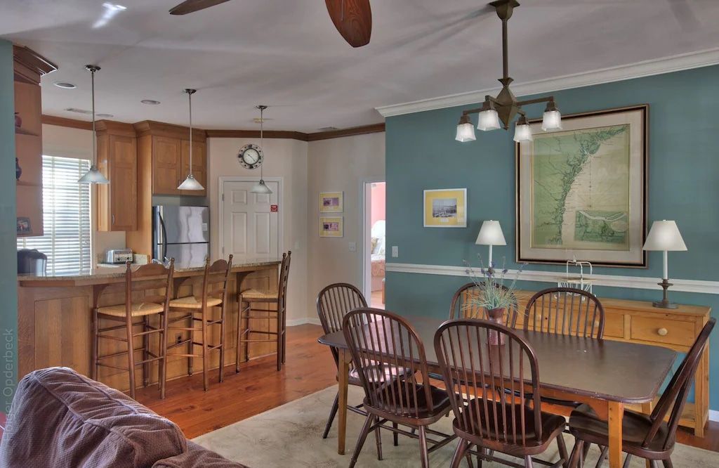 A living room with a table and chairs and a ceiling fan