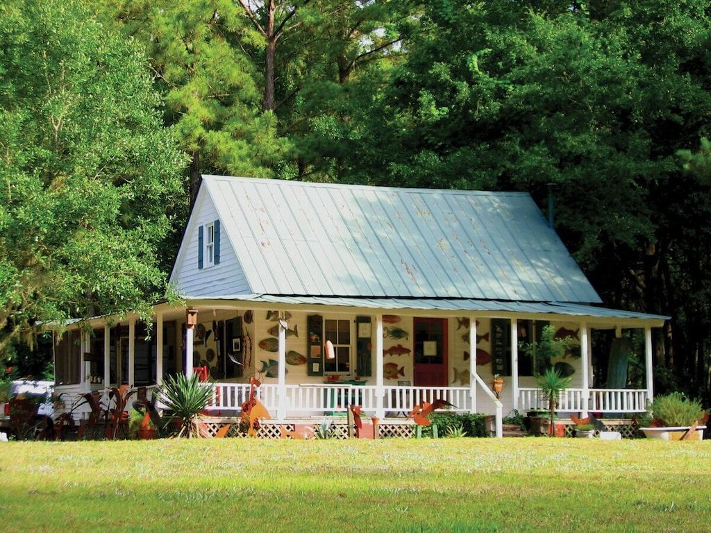 A white house with a porch and the number 11 on the roof