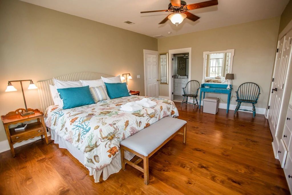 There is a ceiling fan in the bedroom with a large bed.