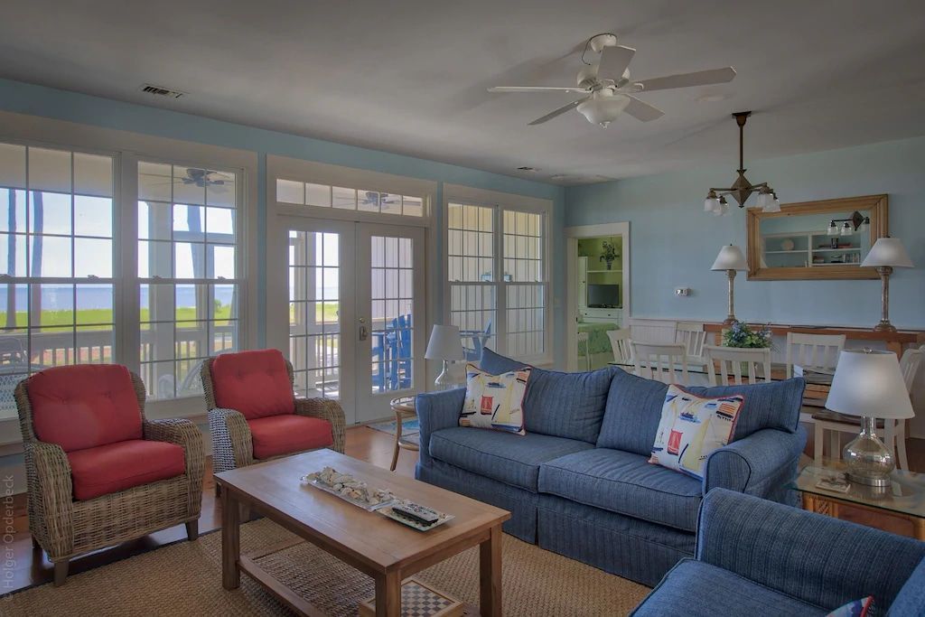 A living room with a blue couch and red chairs