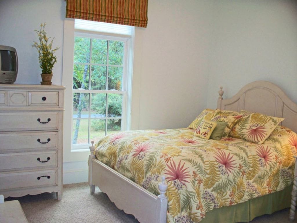 A bedroom with a bed , dresser and television
