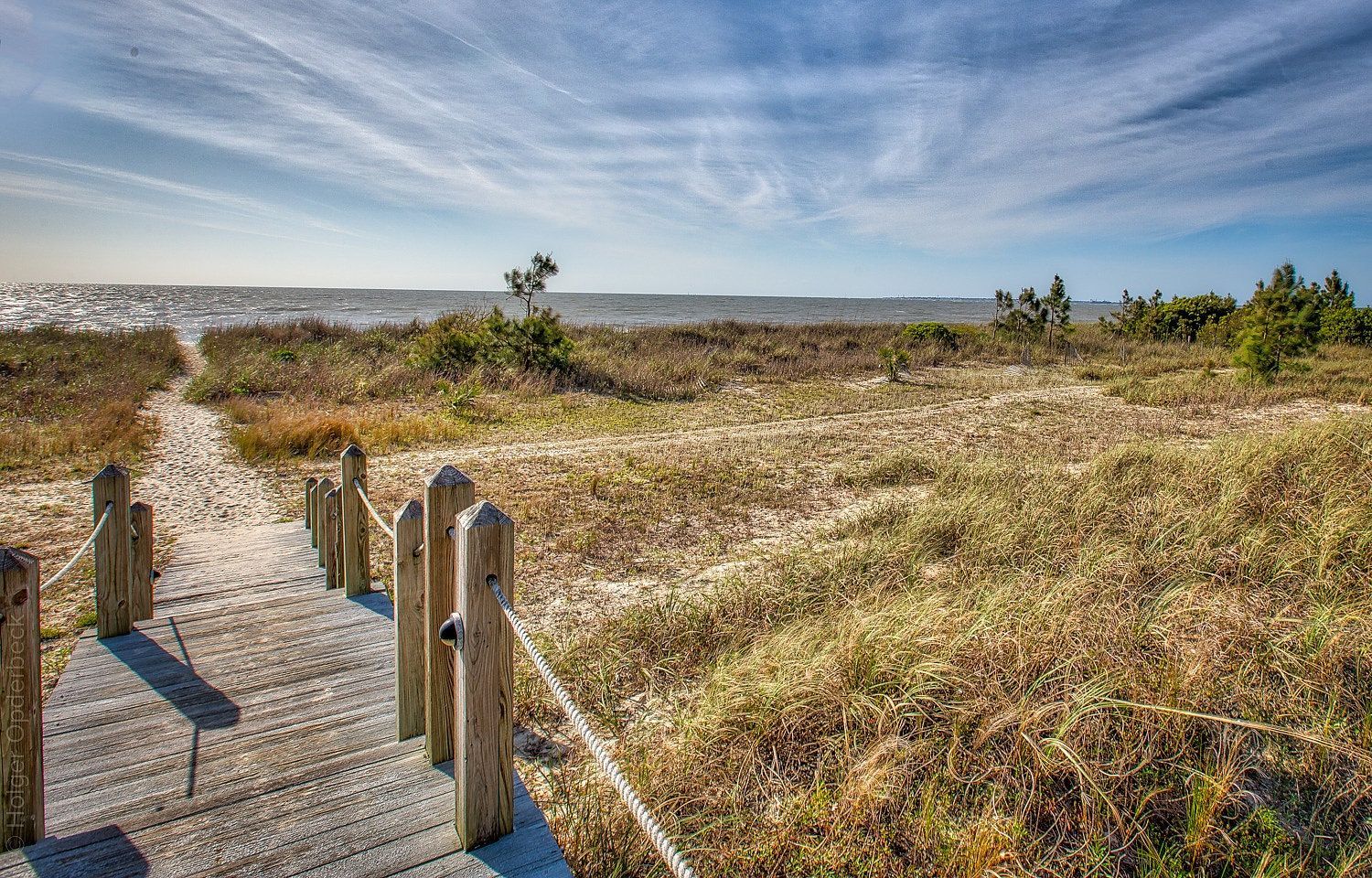 There is a wooden walkway leading to the beach.
