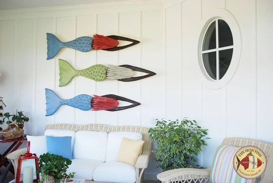 A living room with a couch and three fish on the wall