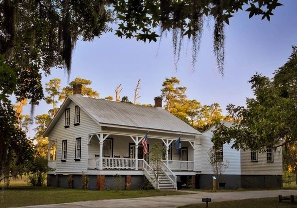 A large white house with a porch and stairs