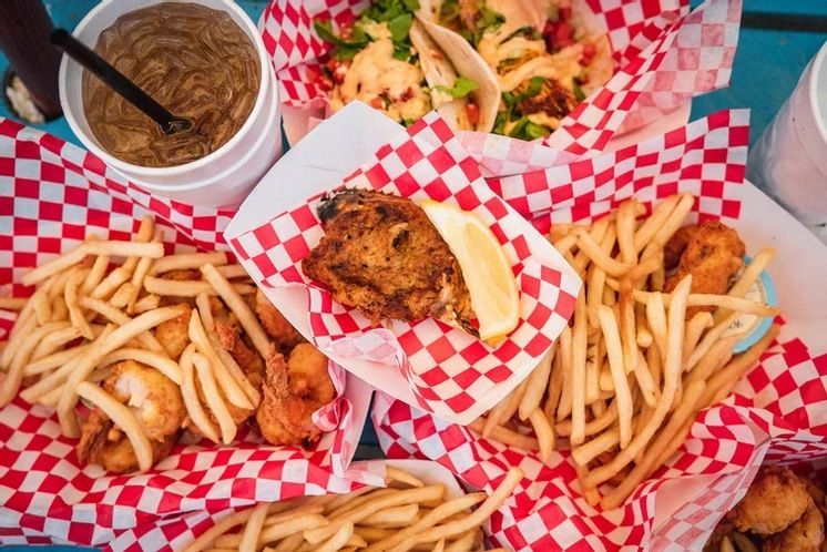 A table topped with a variety of food including french fries and shrimp.