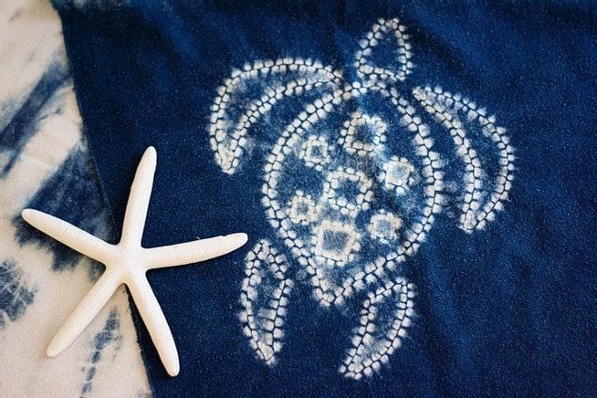 A blue towel with a turtle and starfish on it