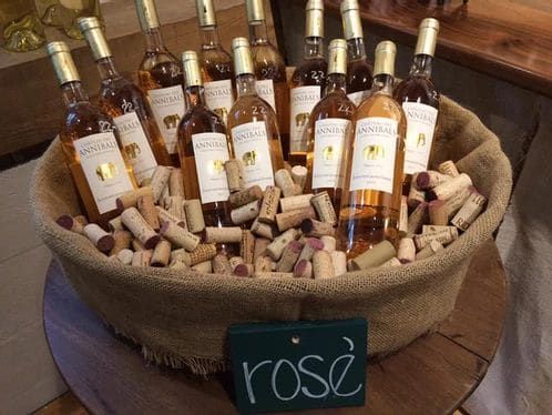 A basket filled with bottles of rose wine and corks