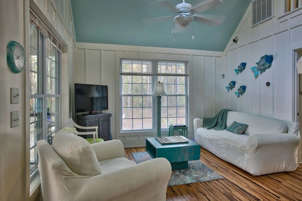 A living room with a couch , chairs , and a ceiling fan.