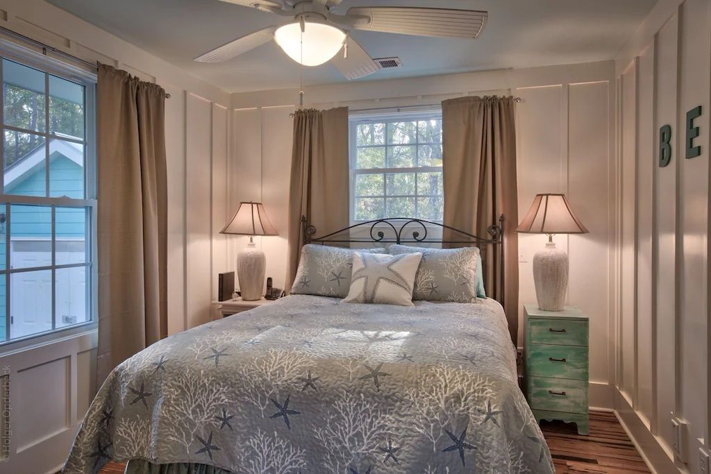 A bedroom with a large bed and a ceiling fan