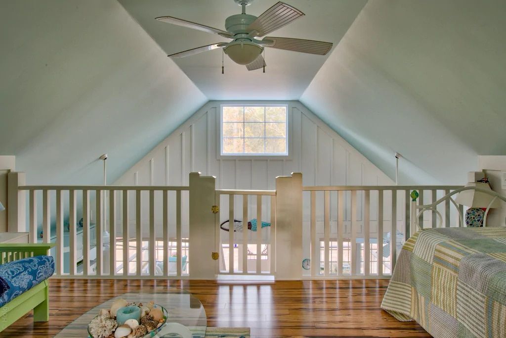 A bedroom with a ceiling fan and a bed