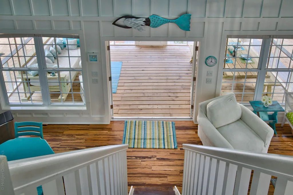 A view of a living room from the top of a staircase.