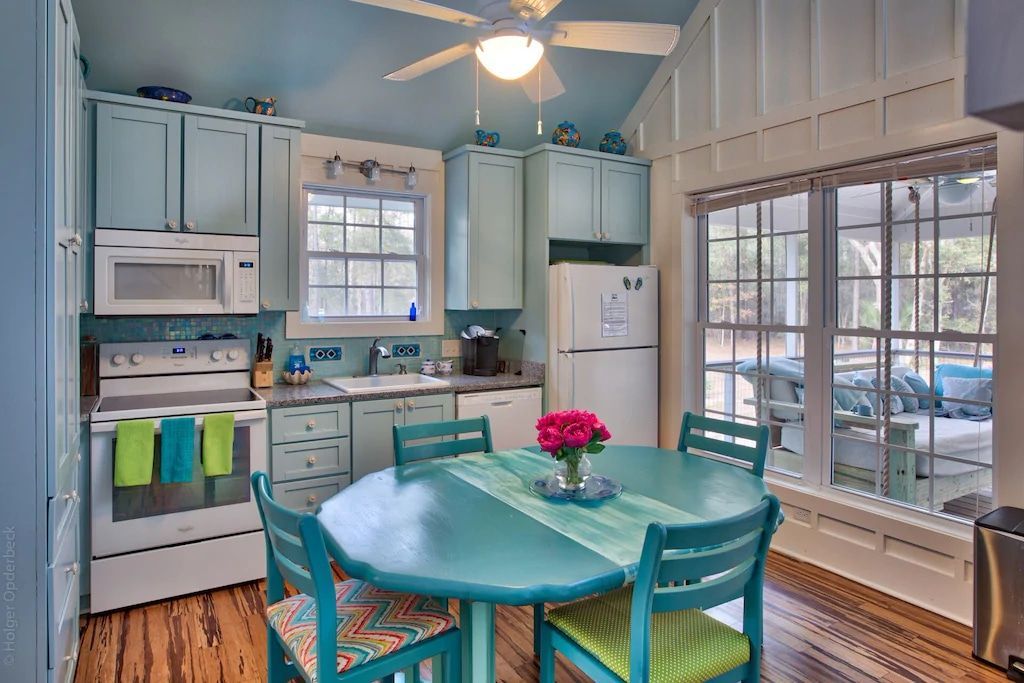 A kitchen with a table and chairs and a ceiling fan
