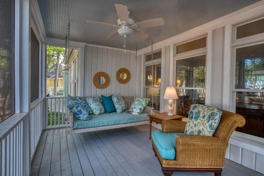 There is a porch with a swing and a ceiling fan.
