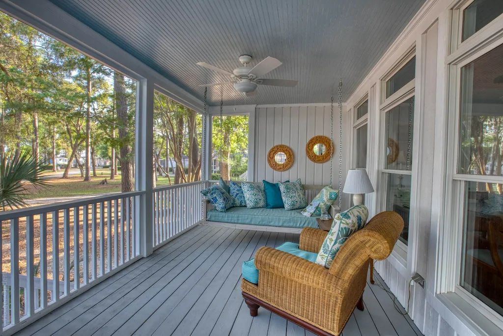 A screened in porch with a couch and chairs