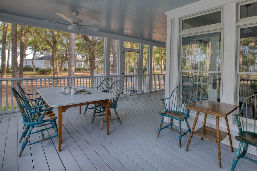A screened in porch with a table and chairs