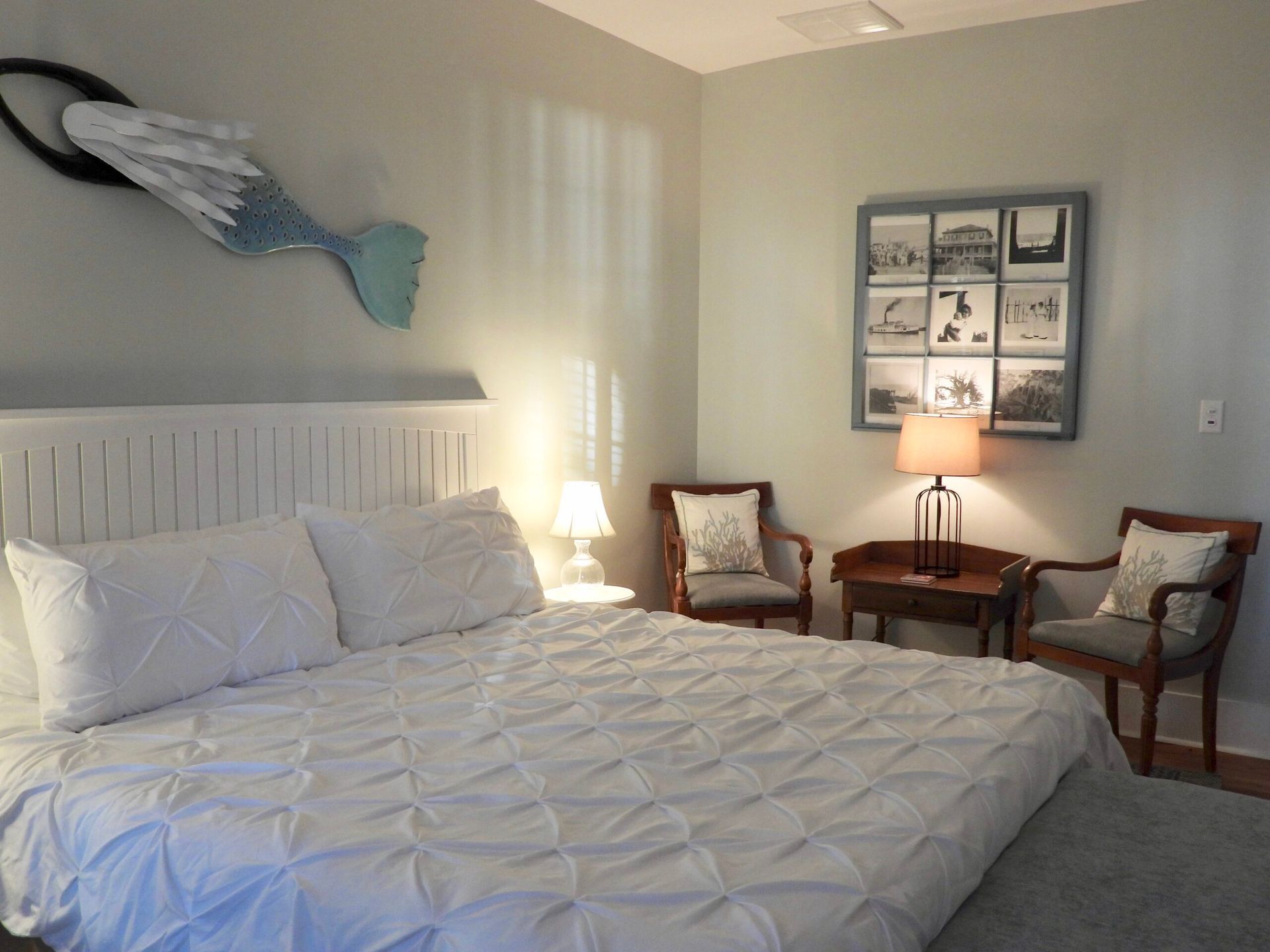 A bedroom with a king size bed and two chairs