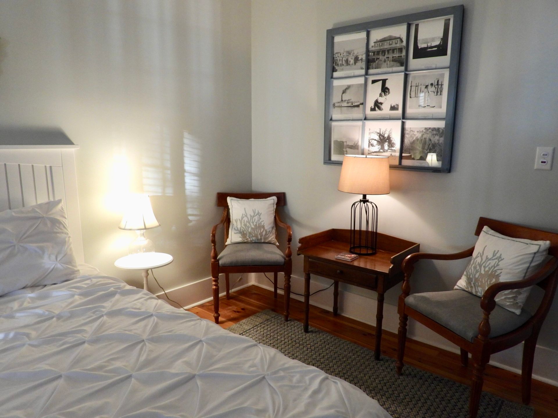 A bedroom with a bed two chairs a table and a lamp