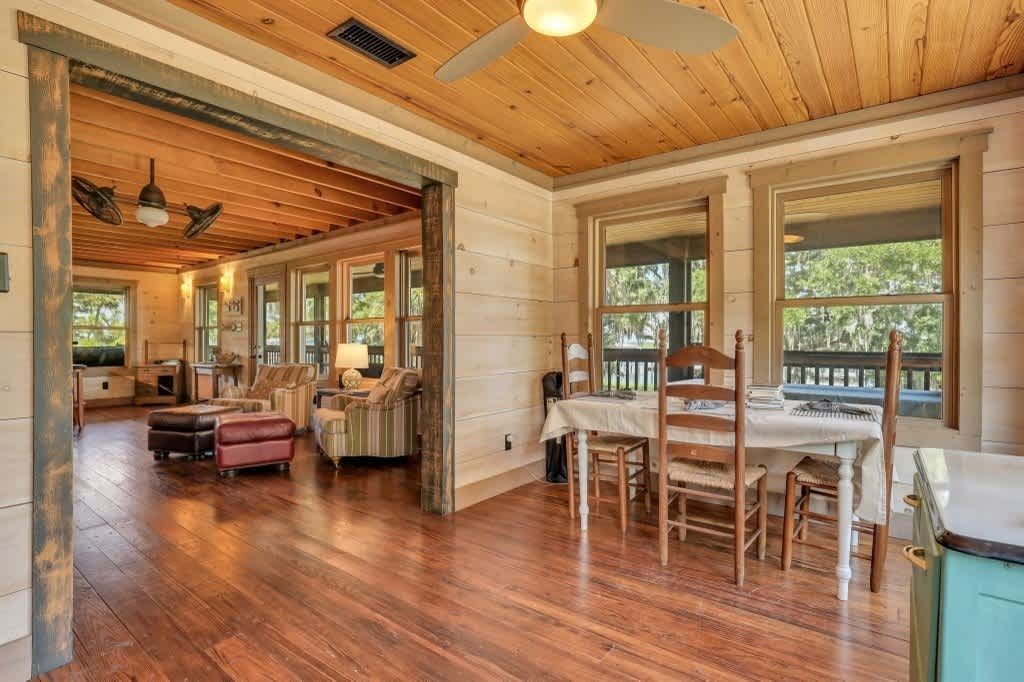 A bedroom with a king size bed , a television , a mirror and a ceiling fan.
