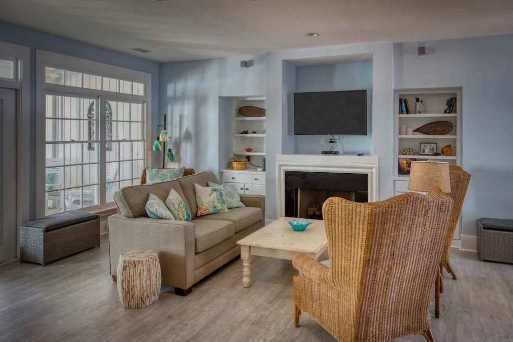 A living room with a couch , chairs , coffee table and television.