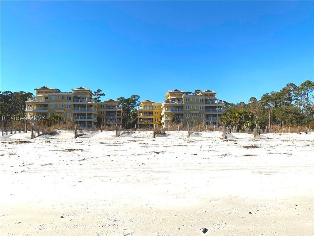 A living room with a blue couch , stairs , fireplace and television.