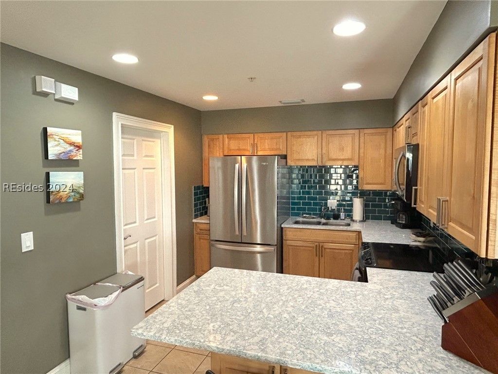 A porch with a row of white rocking chairs on it.