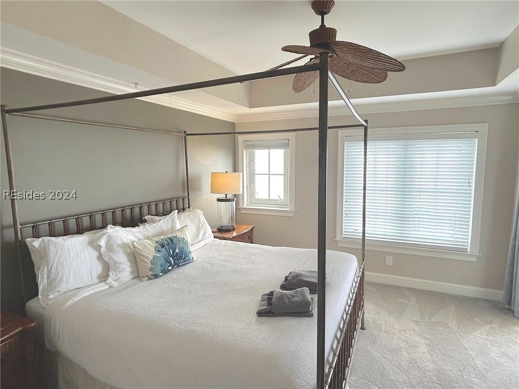 A porch with a table and a ceiling fan.