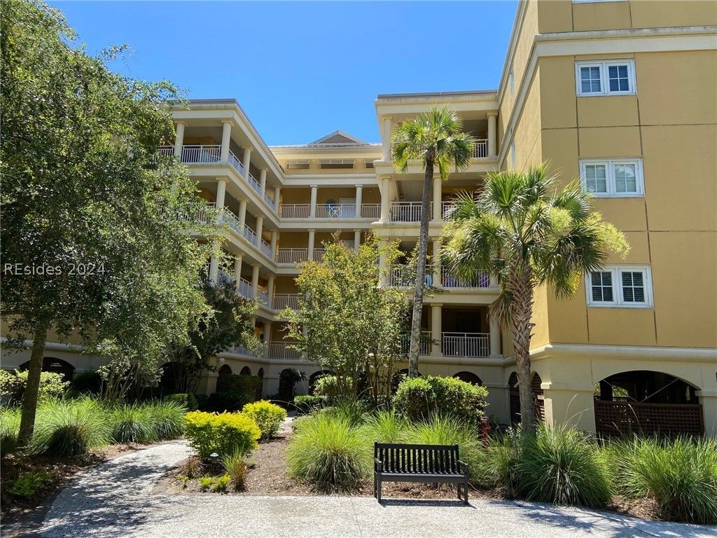 A small house with a screened in porch in the middle of a forest.