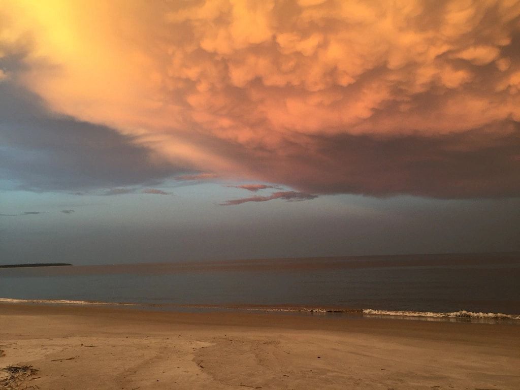 A beach with a cloudy sky in the background