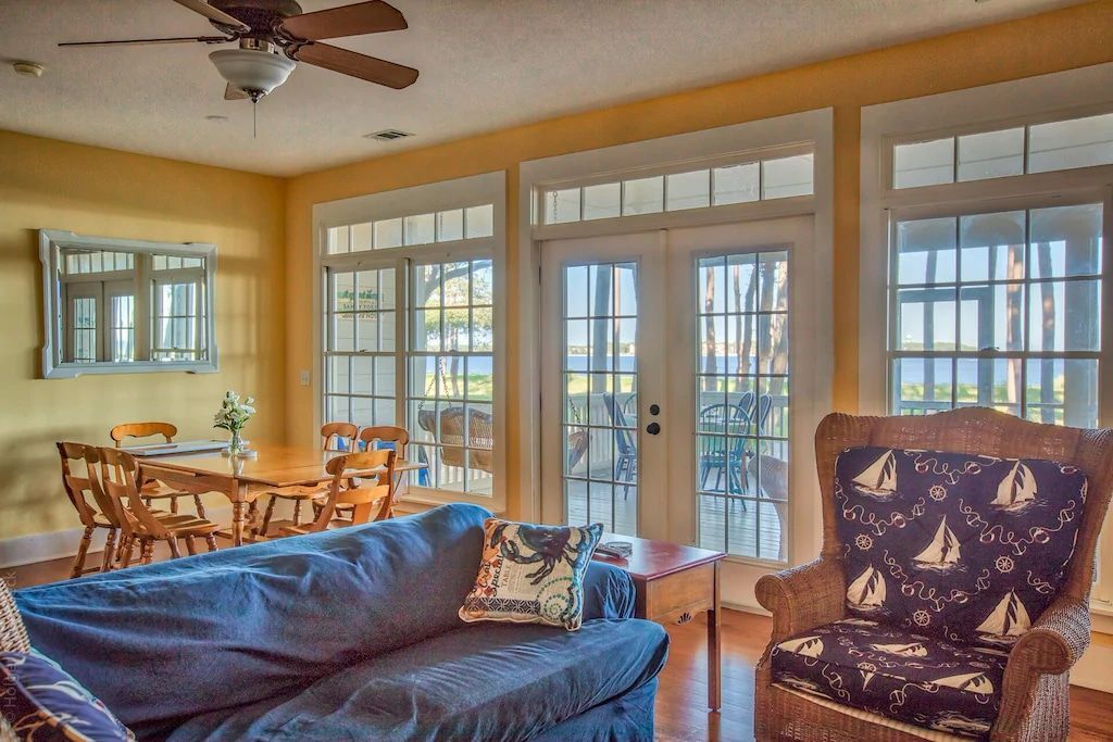 A living room with a couch and chairs and a ceiling fan