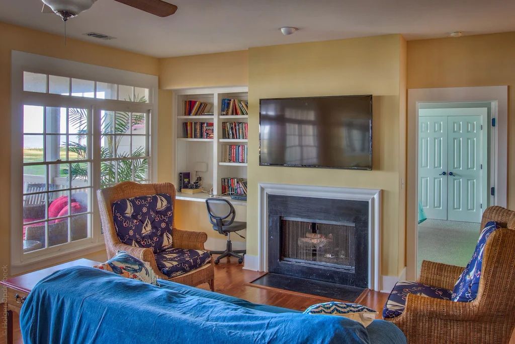 A living room with a fireplace and a flat screen tv.