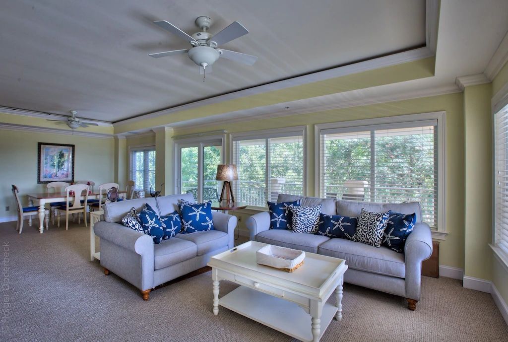 A living room with two couches , a coffee table and a ceiling fan.