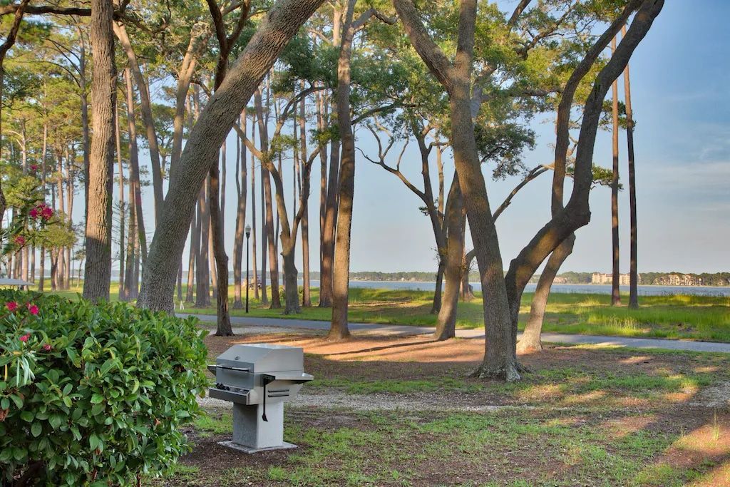 A picnic table is sitting in the middle of a park surrounded by trees.