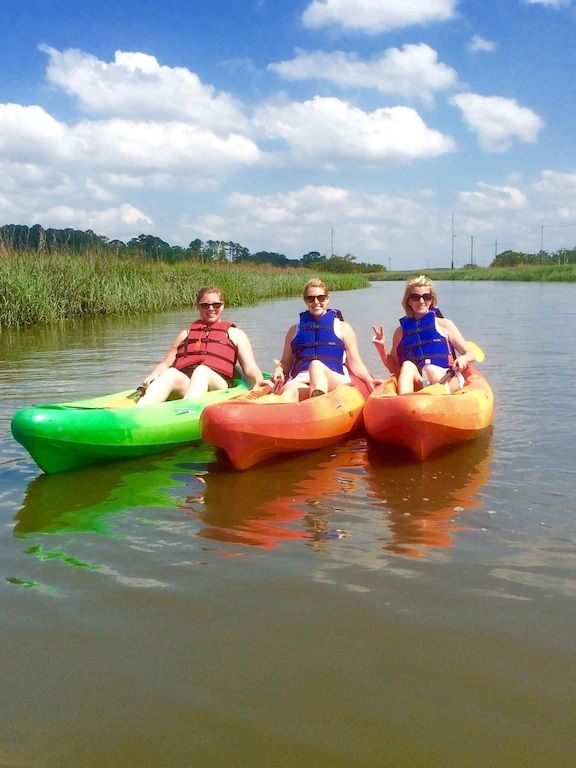 Three people are sitting in kayaks on a lake