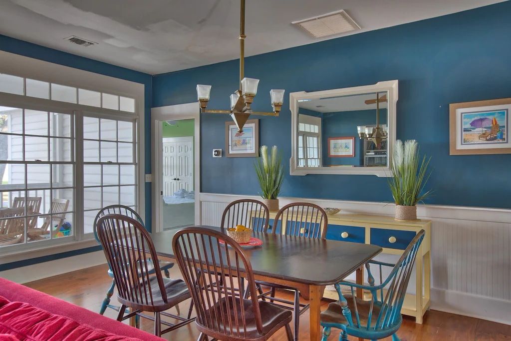 A dining room with a table and chairs and blue walls