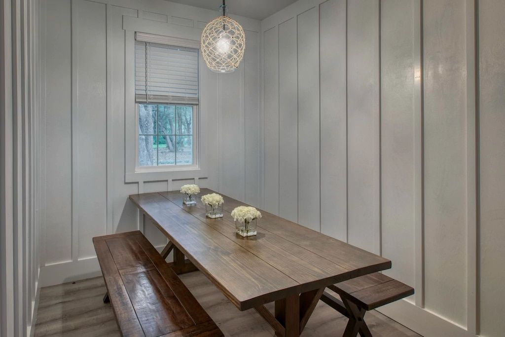 A dining room with a long wooden table and benches.