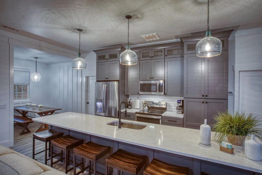 An artist 's impression of a kitchen with a large island and stools.
