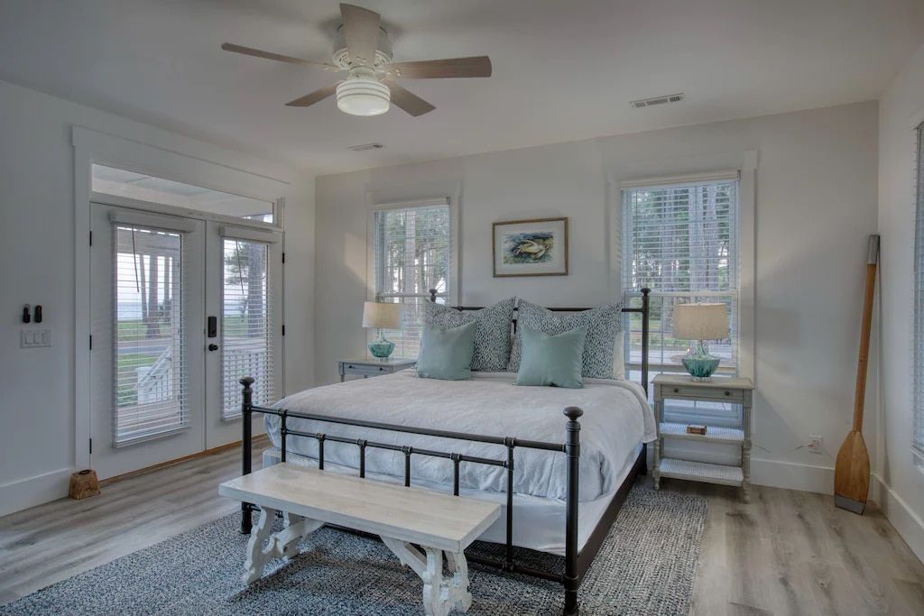 A bedroom with a king size bed and a ceiling fan.