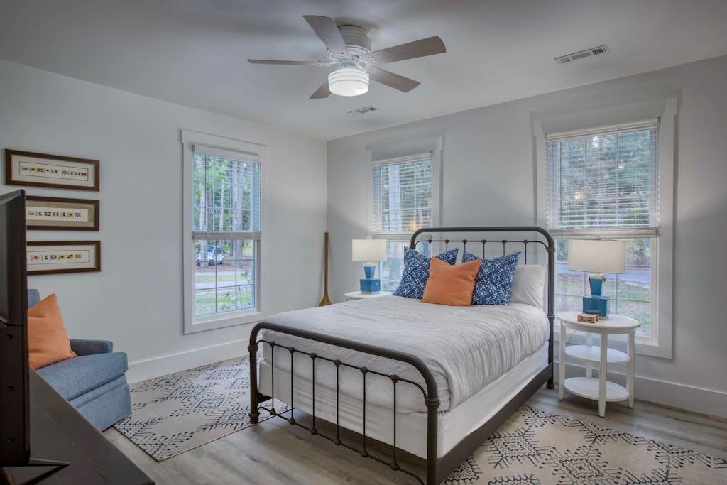 A bedroom with a king size bed , a television , and a ceiling fan.