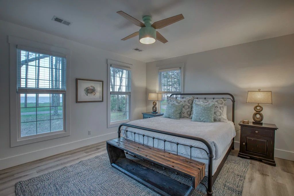 A bedroom with a king size bed and a ceiling fan.
