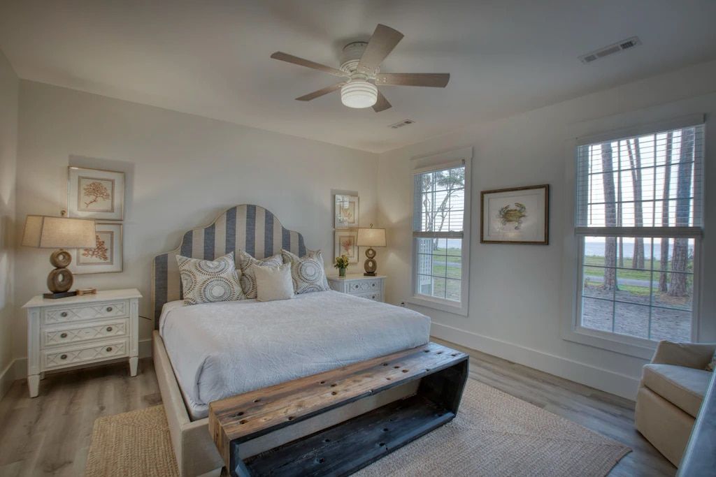 A bedroom with a king size bed and a ceiling fan.