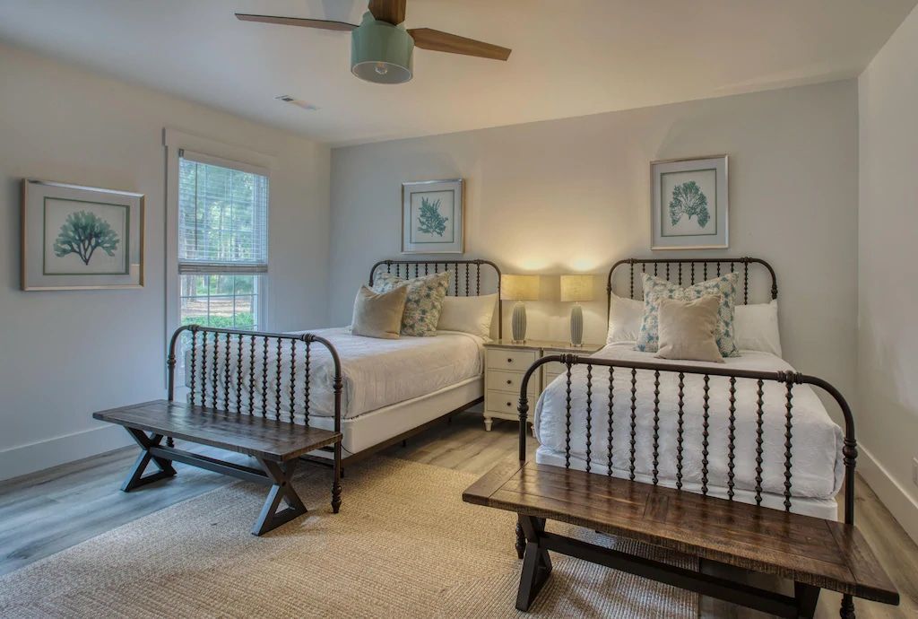 A bedroom with two beds and a ceiling fan.