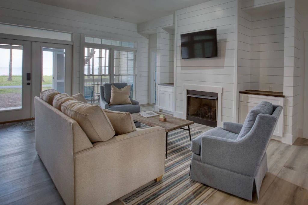 A living room with a couch , chair , television and fireplace.