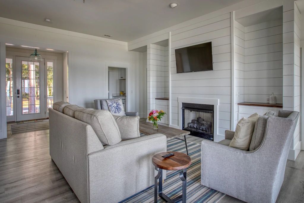 A living room with a couch , chair , fireplace and television.