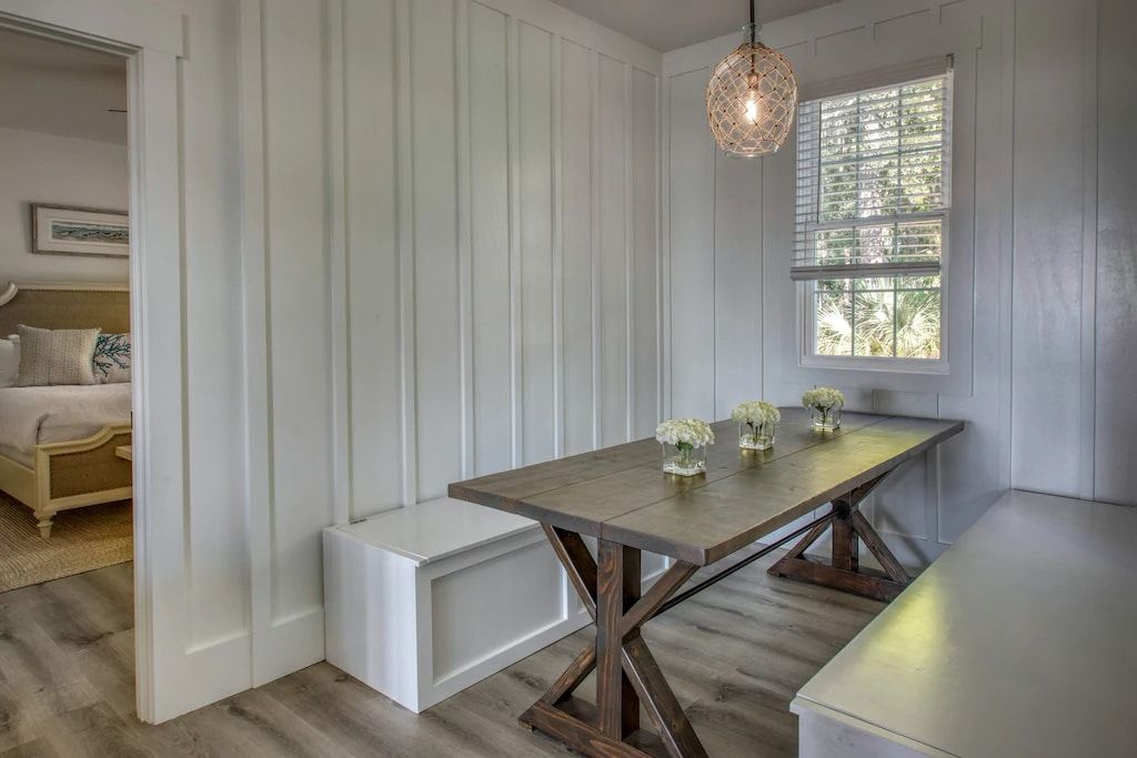 A dining room with a table and bench and a window.
