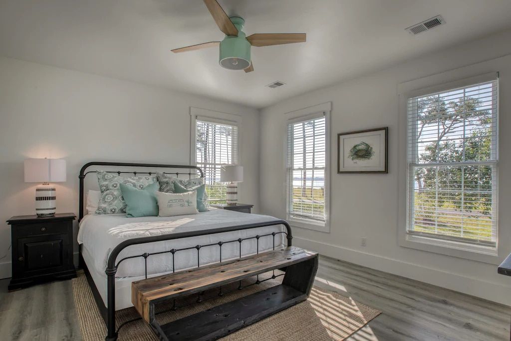 A bedroom with a king size bed and a ceiling fan.