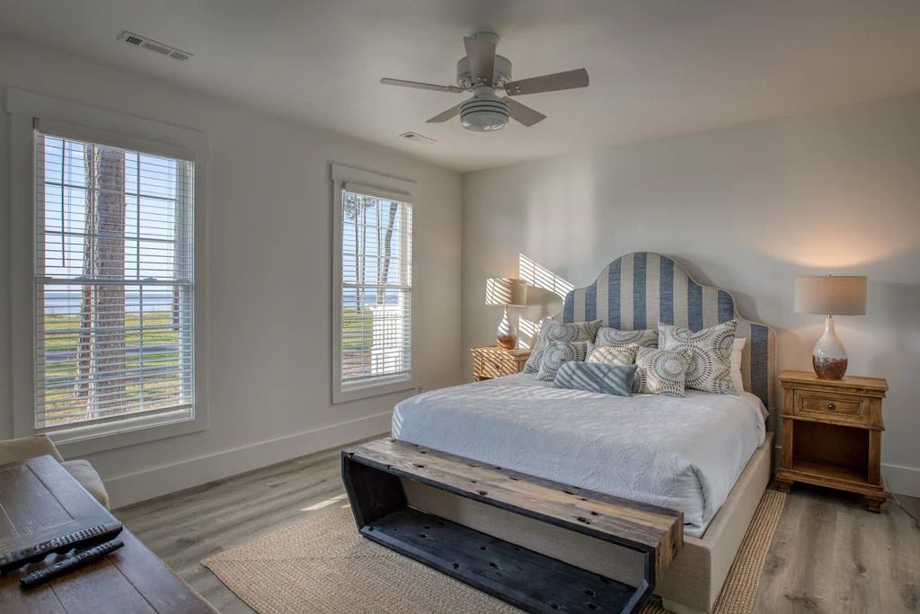 A bedroom with a king size bed and a ceiling fan.