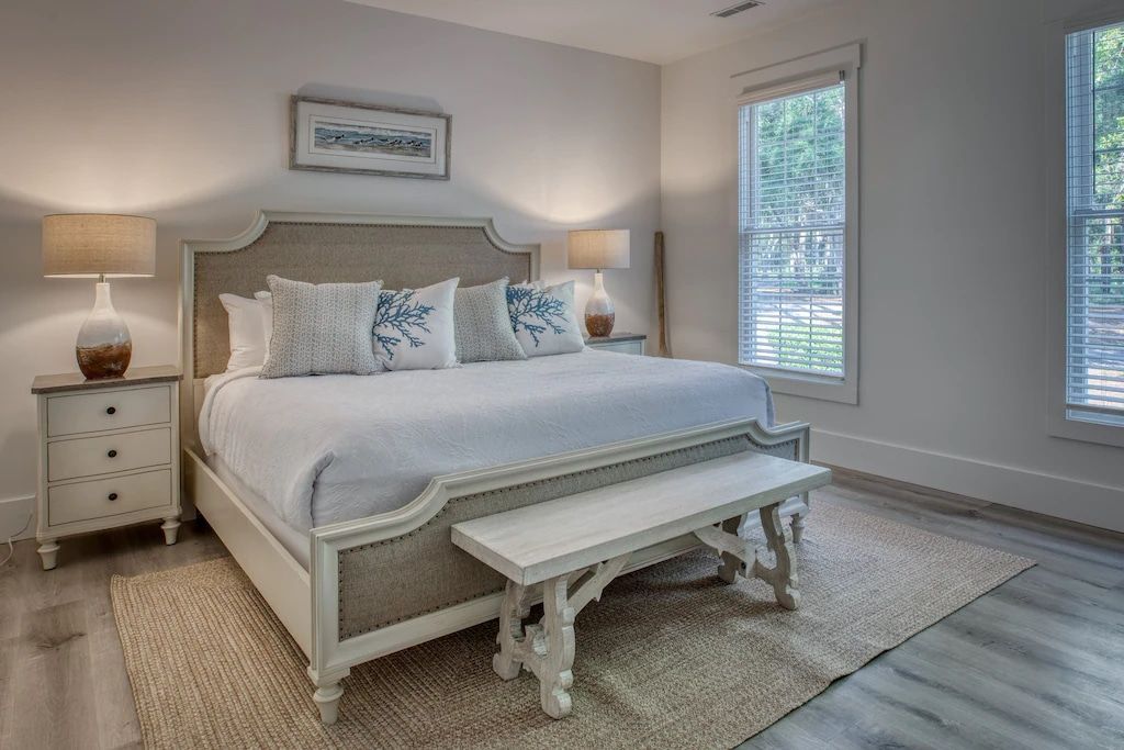 A bedroom with a king size bed and a bench.