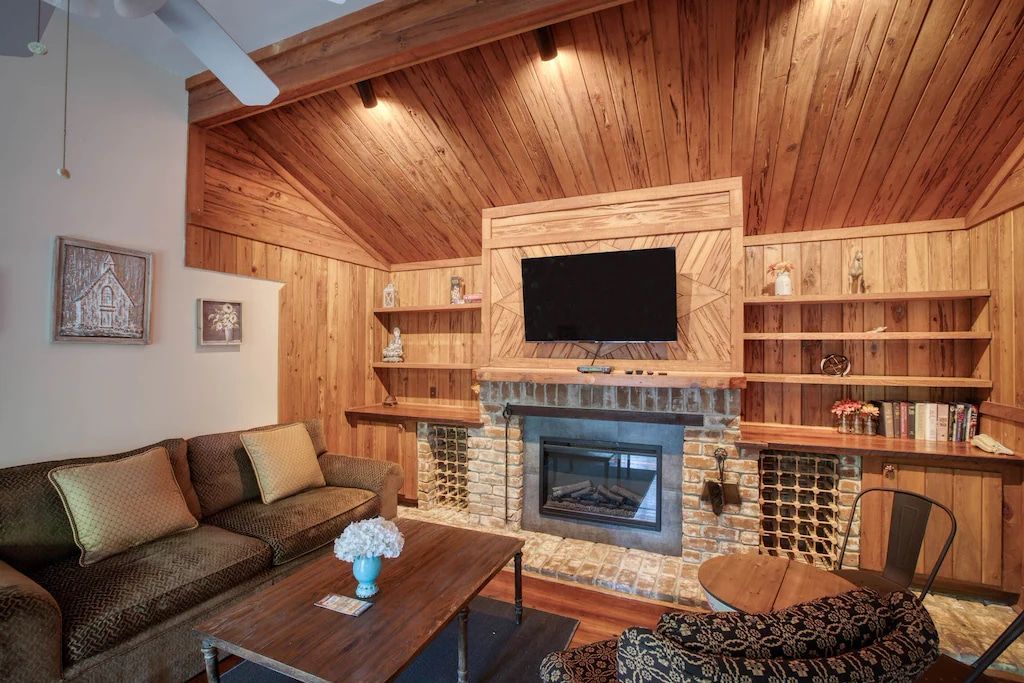 A living room with a fireplace and a flat screen tv.