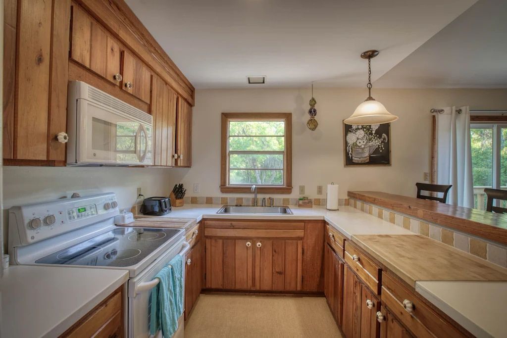 A kitchen with wooden cabinets and a stove and microwave